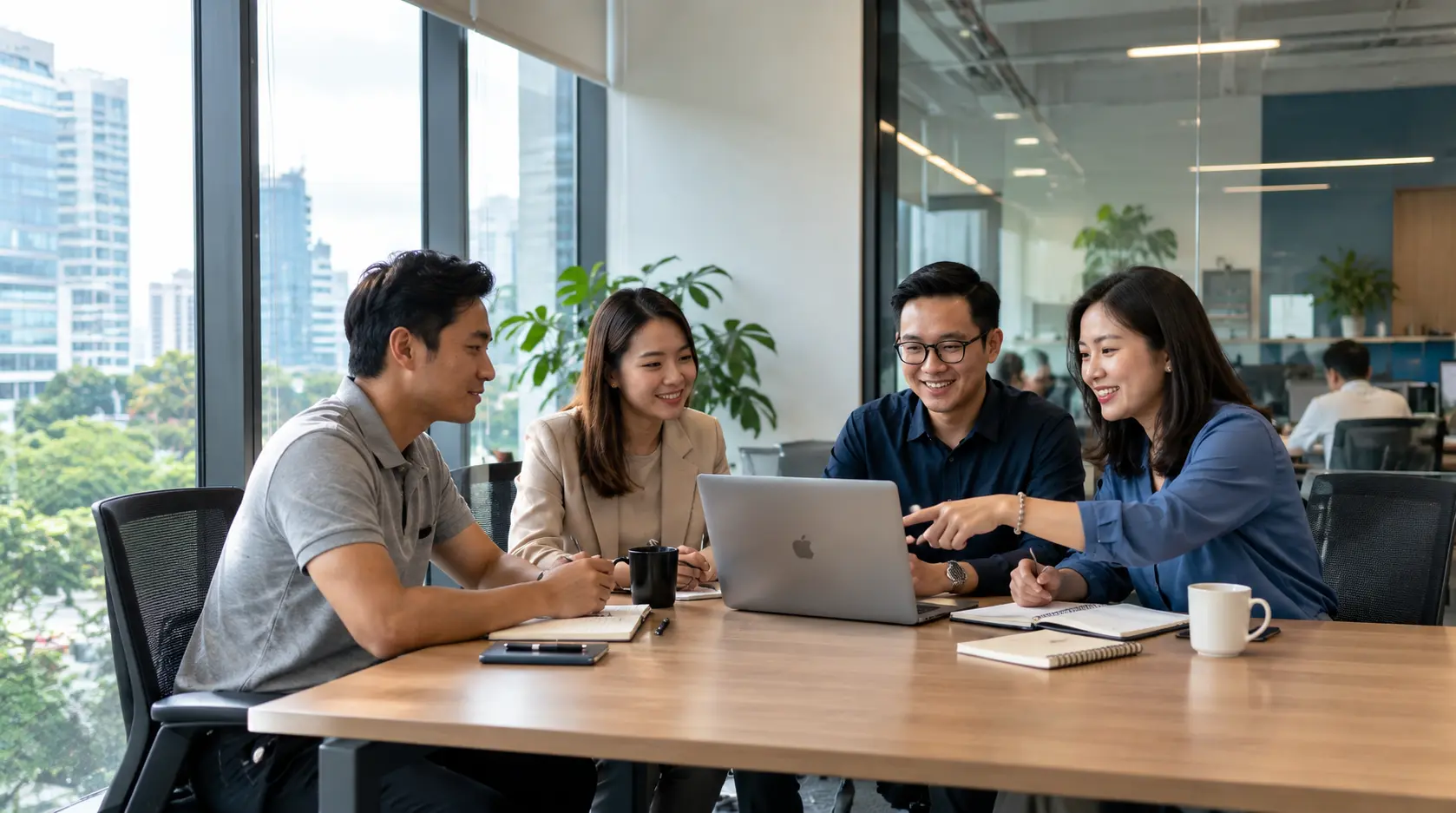 Nhóm bốn người trao đổi quanh một chiếc laptop